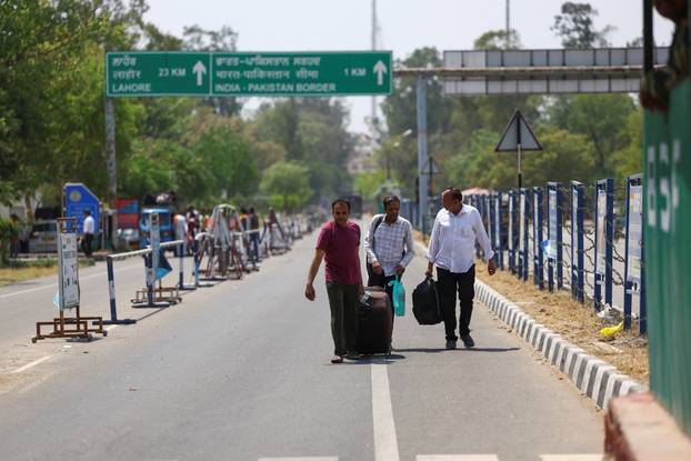 An Indian citizen, Khalid (centre), enters India after Pakistan revoked all visas issued to Indian citizens, at the Attari-Wagah border crossing near Amritsar